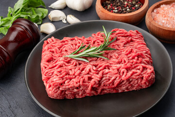 Raw ground meat on black stone table background