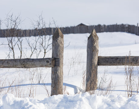 A wooden fence with two posts and a gate