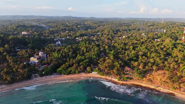 Drone flying backwards over Hiriketiya beach along Sri Lanka's south coast