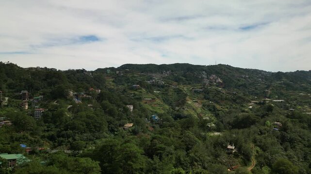 Panoramic aerial view of scattered mountain settlements and dense forest greenery at La Trinidad, Benguet Province, Philippines