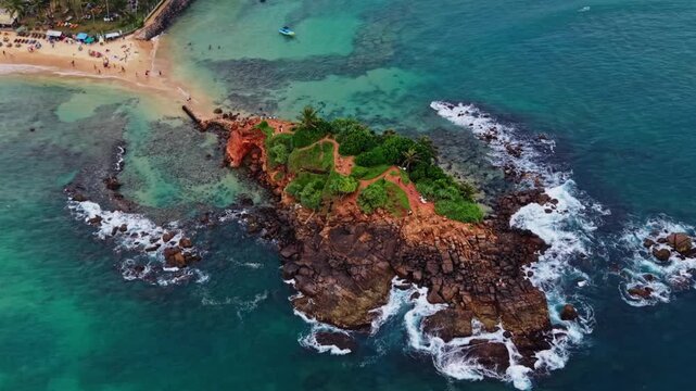 Cinematic drone pan around vibrant parrot rock in Sri Lanka at sunset