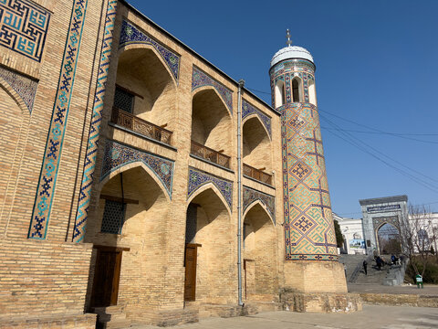 Kukeldash Madrasah exterior in Tashkent, Uzbekistan. Historic Islamic school with tiled minaret and ornate portal, Uzbek cultural landmark. 