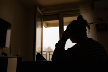 Woman with headache, depression, sadness and loneliness at home.