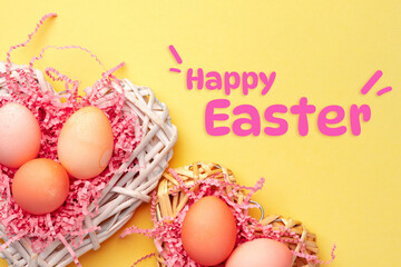 Fototapeta premium Colorful Easter eggs in a basket with Happy Easter text on a bright background
