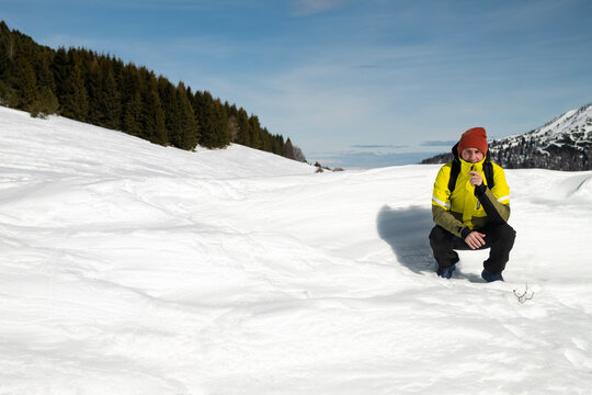Tourist portrayed on a snow-capped mountain. The man is forty-two years old, of Caucasian origin and wears a yellow and green ski jacket