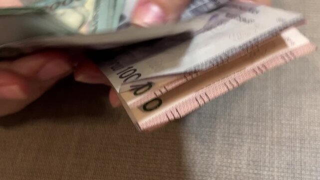 Horizontal video close up. Woman count paper purple, red Armenian banknotes 20000, 10000 5000, 1000, dram on wood table. Cash money. Concept of budget, salary, bribe, debt, loan, pay tax, travel