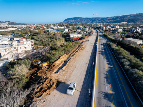 Aerial view of a newly constructed highway cutting through the landscape, the raw earth contrasting with the smooth asphalt, Chania, Chania, Greece.