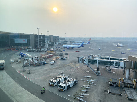 Mumbai, India - October 22, 2025: Chhatrapati Shivaji International Airport view with aircraft, ground vehicles, and terminal buildings during sunset in Mumbai, India