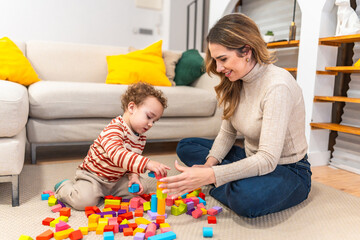 Naklejka premium Mother and toddler building with colorful wooden blocks on floor