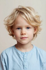 Naklejka premium Blond child standing still portrait in neutral indoor setting