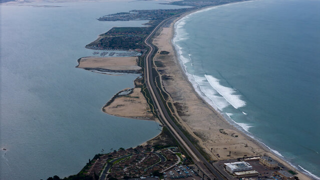 Aerial view of a narrow isthmus separating the bay from the ocean, with sandy beaches and a glimpse of Coronado Cays, Coronado, California, United States.