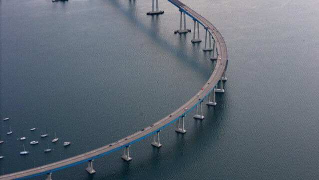 Aerial view of the graceful curve of the Coronado Bridge stretching across the bay, a ribbon of concrete and steel connecting to the distant shore, Coronado, California, United States.