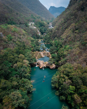Aerial view of the turquoise river winding through the verdant valley, crowned by rugged mountains, San Luis Potosi, San Luis Potosi, Mexico.