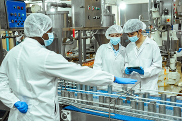 Food safety supervisors conduct HACCP inspection on canned seafood production line, monitoring...