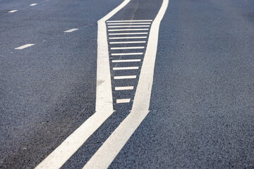 Asphalt road with painted traffic lane markings on a clear day perspective view.