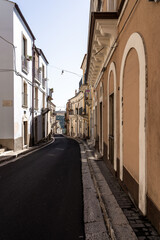 Naklejka premium Empty sicilian old town street with historic buildings and balconies