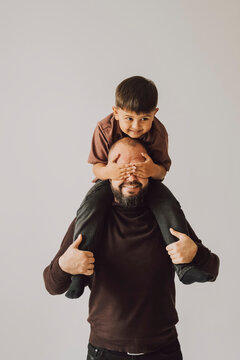 Father playing with child on shoulders indoors family bonding