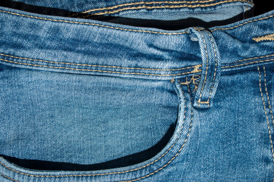 Primer plano del bolsillo de un pantal&oacute;n vaquero azul y detalle de las costuras.