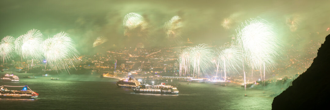 Firework display over Funchal harbor with cruise ships at evening twilight