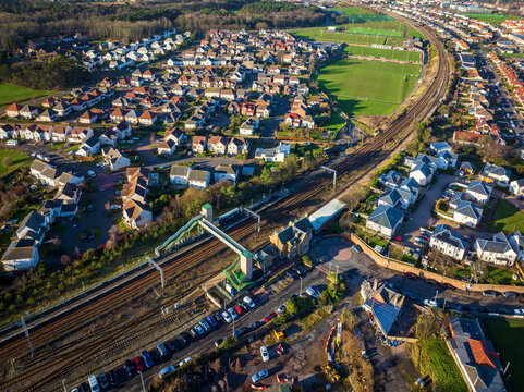 Aerial view of the train station nestled among rows of houses and green fields, Dunbar, Scotland, United Kingdom.