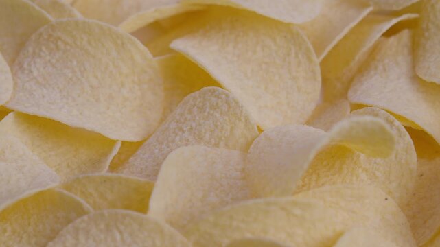 Vivid closeup of golden seasoned crunchy potato slices for advertising, Detailed and colorful closeup photo of stacked salted potato crisps arranged closely together