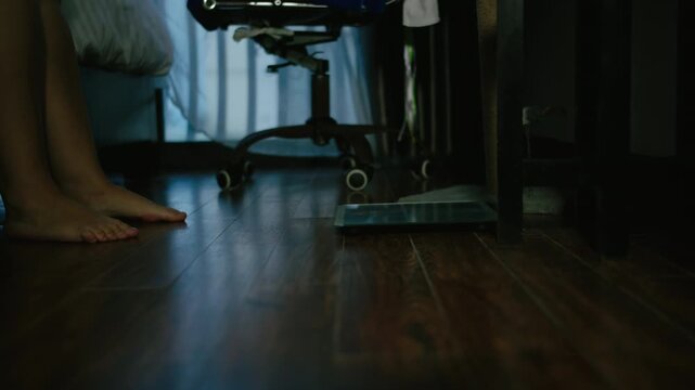 Overweight Woman Getting Out of Bed and Standing on Scale in Evening