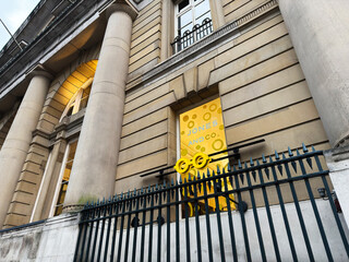 Obraz premium Historic Manchester Jones And Co Styling Opticians office building with yellow signage and iron fence in front