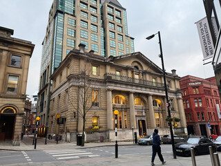 Obraz premium Historic and modern Manchester street scene with grand Former Bank of England building and pedestrians in the UK