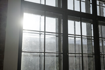 Light shines through dirty windows in a building during late afternoon hours in the city
