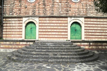 Stone and Brick Wall with Ancient Architectural Detail and Decorative Metal Historical Door and Stone Staircase