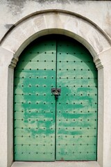 Weathered Green Door Featuring Traditional Metalwork