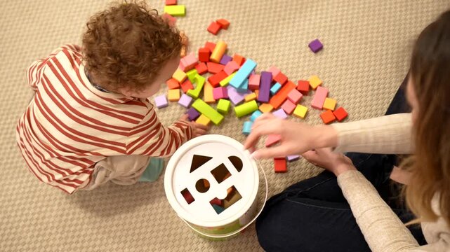 Toddler boy learning shapes with educational sorter toy