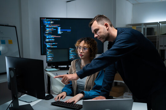 software developer talk strategy plan to executive write prompt AI bot IT app program data analytics in tech startup office.Projected visuals and glowing code on screen.AI chatbot technology concept
