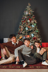 Woman decorates Christmas tree indoors in clear evening light