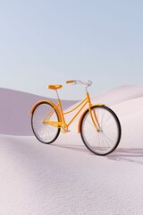 Fototapeta premium a yellow bicycle on a sand dune, with a clean sky background.