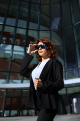 Fototapeta premium Happy Businesswoman Portrait With Sunglasses In Urban Corporate Setting