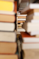 Fototapeta premium Close-up of stacked books from a bookshelf, view from the spines, education and knowledge concept.