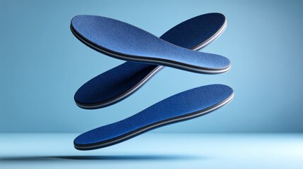 Obraz premium Blue insoles with textured surface and cushioning layers floating against a light blue background, showcasing their ergonomic design and comfort features