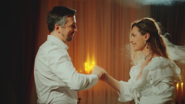 Two person happy couple dancing together man king holding hand sexy noble woman queen. Night dark room candles light. Adult girl princess guy prince old style, love medieval ball room themed party 4k