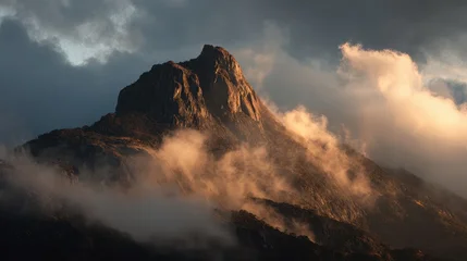 Majestic Mountain Peak Emerging from Dramatic Clouds at Golden Hour © Pixelzone