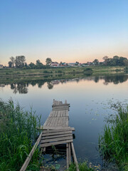 Fototapeta premium Calm River With Wooden Pier At Dusk