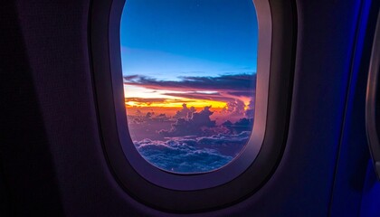 Fototapeta premium Breathtaking aerial vista showcases a vibrant tapestry of clouds ablaze with the golden, orange, and purple hues of a spectacular sunset, viewed from an aircraft window during flight