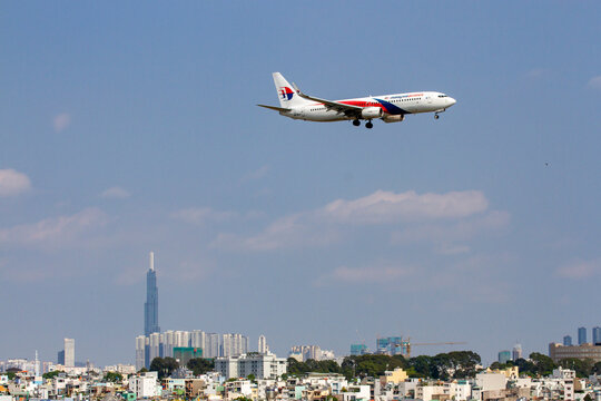 Ho Chi Minh City, Vietnam - September 21, 2019 : A Boeing 777-300ER Airplane Of Malaysia Airlines Landing At Tan Son Nhat International Airport With Landmark 81 Skyscrapers In The Distance.