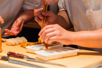 Obraz premium Skilled chef preparing sushi with fresh ingredients and precise techniques