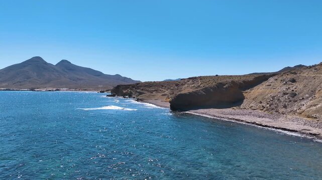 Aerial cruises low over the crystal clear waters of La Isleta del Moro anchorage