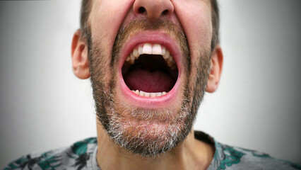 An open mouth of a man screaming madly