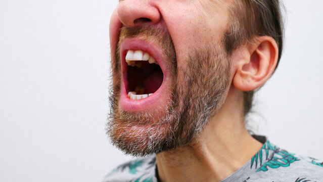 An open mouth of a man screaming madly
