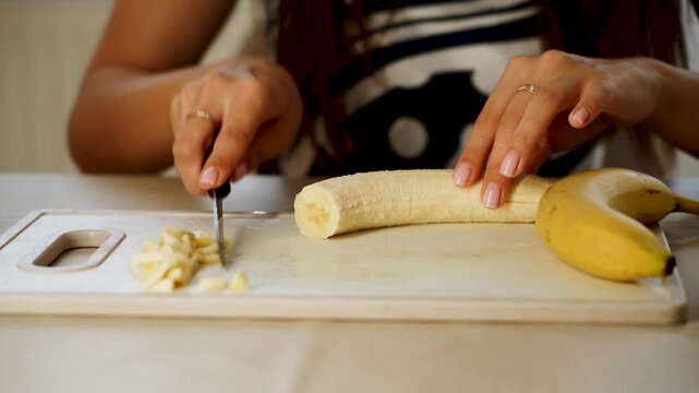 Slicing banana and preparing fruit for a simple snack in a kitchen setting