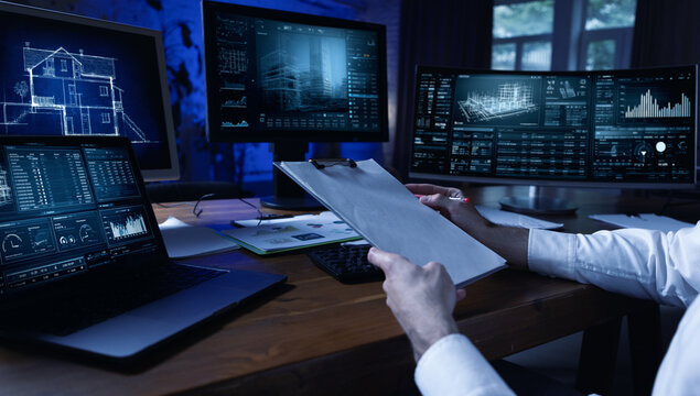 Technical mixed media. Business analyst reviewing architectural plans and financial reports. Concept of real estate analytics, infrastructure planning and investment evaluation.