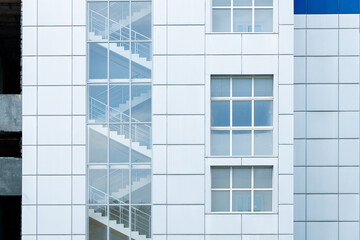 Fototapeta premium Modern building facade with glass staircase and windows, architectural detail